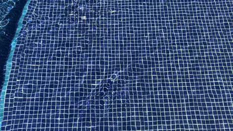 a relaxing image of water moving over a mosaic blue tile background