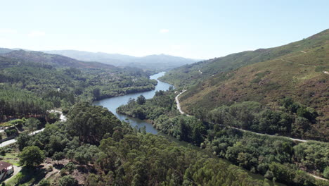 establishing shot revealing a river flowing through a valley and leading to a mountain in the distance