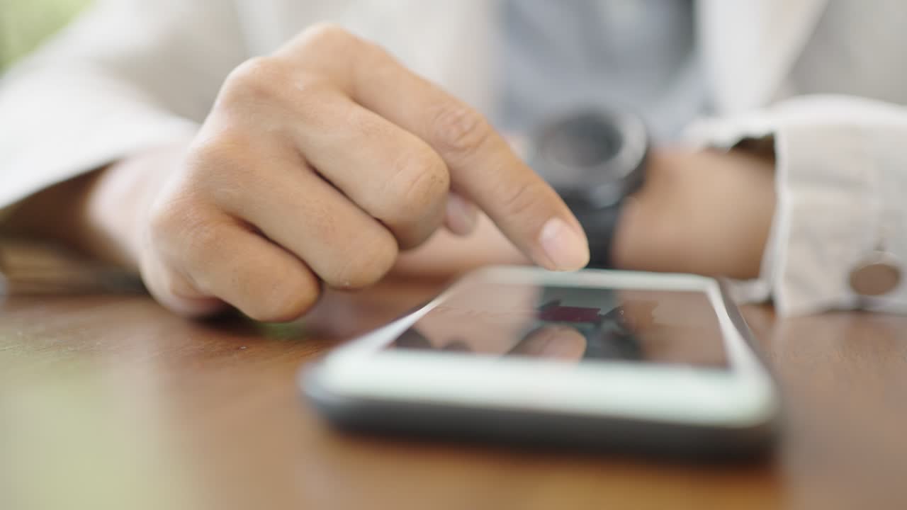 un joven empresario con una máscara quirúrgica está tomando una videoconferencia con los clientes a través de un teléfono inteligente conectado a internet.