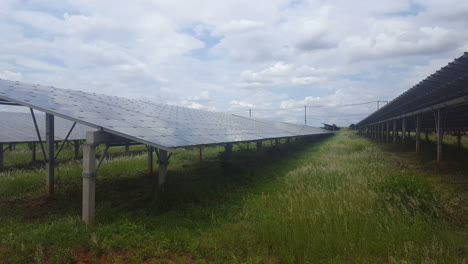 Panorámica-A-La-Derecha-De-Una-Gran-Planta-Solar-Con-Una-Gran-Matriz-Fotovoltaica-En-Un-Hermoso-Día-Con-Nubes-Blancas-Y-Cielo-Azul