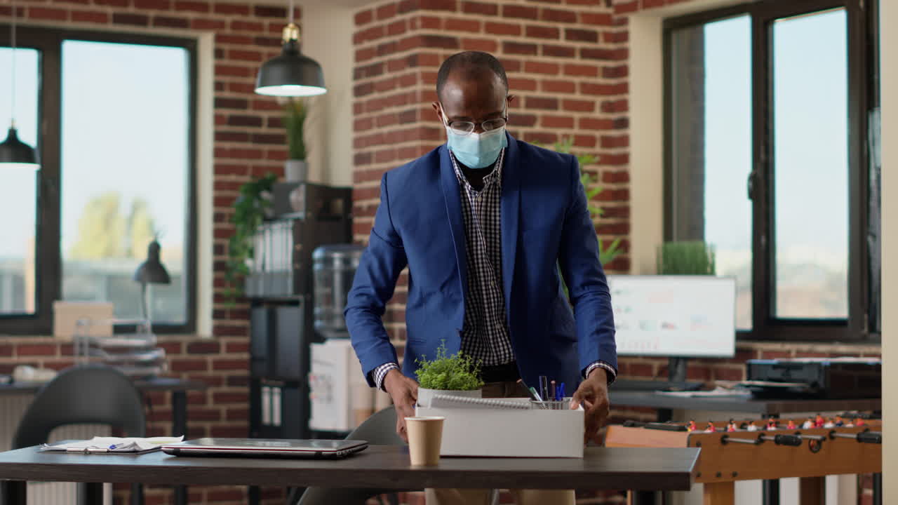Upset distraught man packing up office things after getting fired