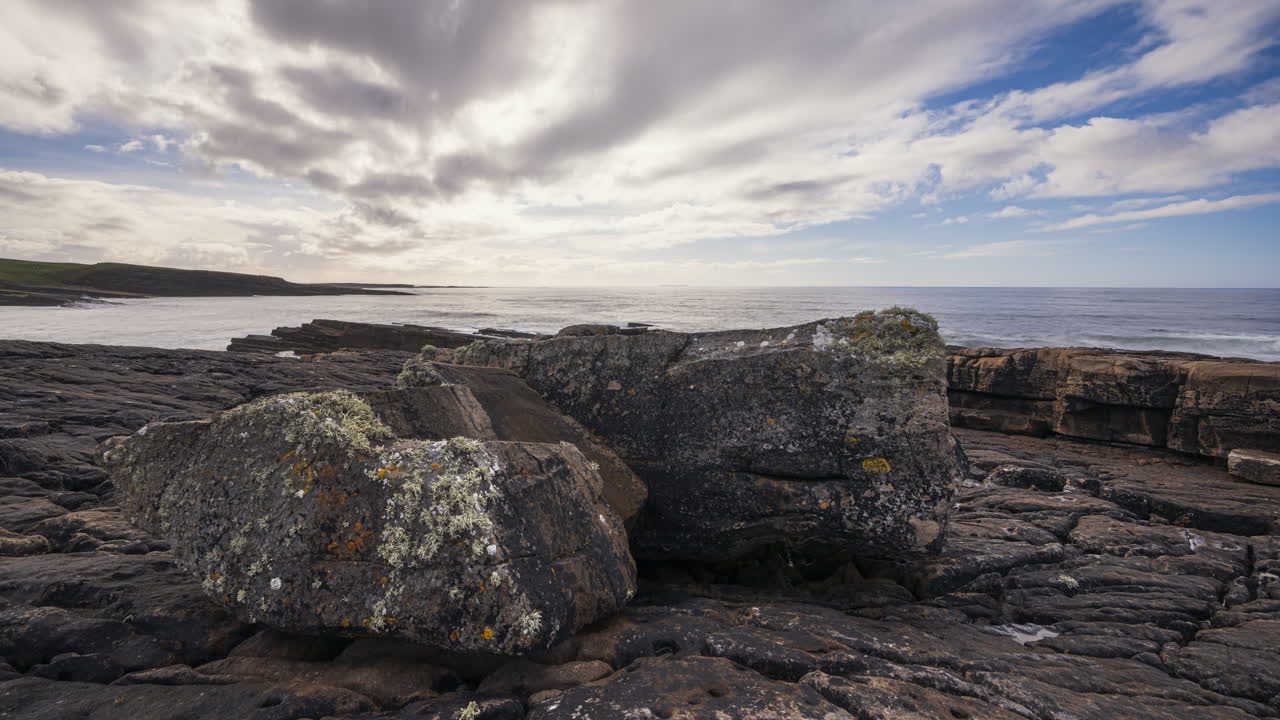 Panorama motion timelapse of rugged rocky coastline on sunny cloudy day with Classiebawn castle in distance in Mullaghmore Head in county Sligo on the Wild Atlantic Way in Ireland