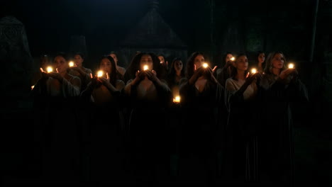 women holding glowing lights during a nocturnal ceremony