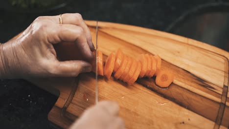 chopping carrots on wooden board top down view perspective