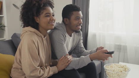 young couple choosing a film with the remote control