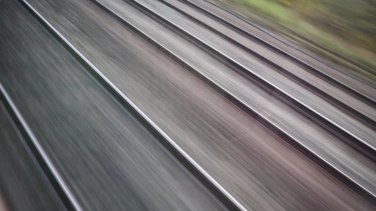 Train tracks from an passenger's angle while another train passes by.