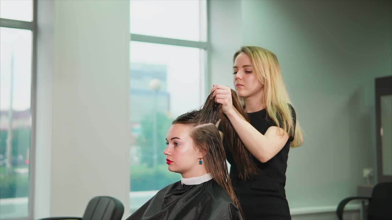 여자 가 헤어 드레이서 에 의해 머리 를 스타일링 하고 있다