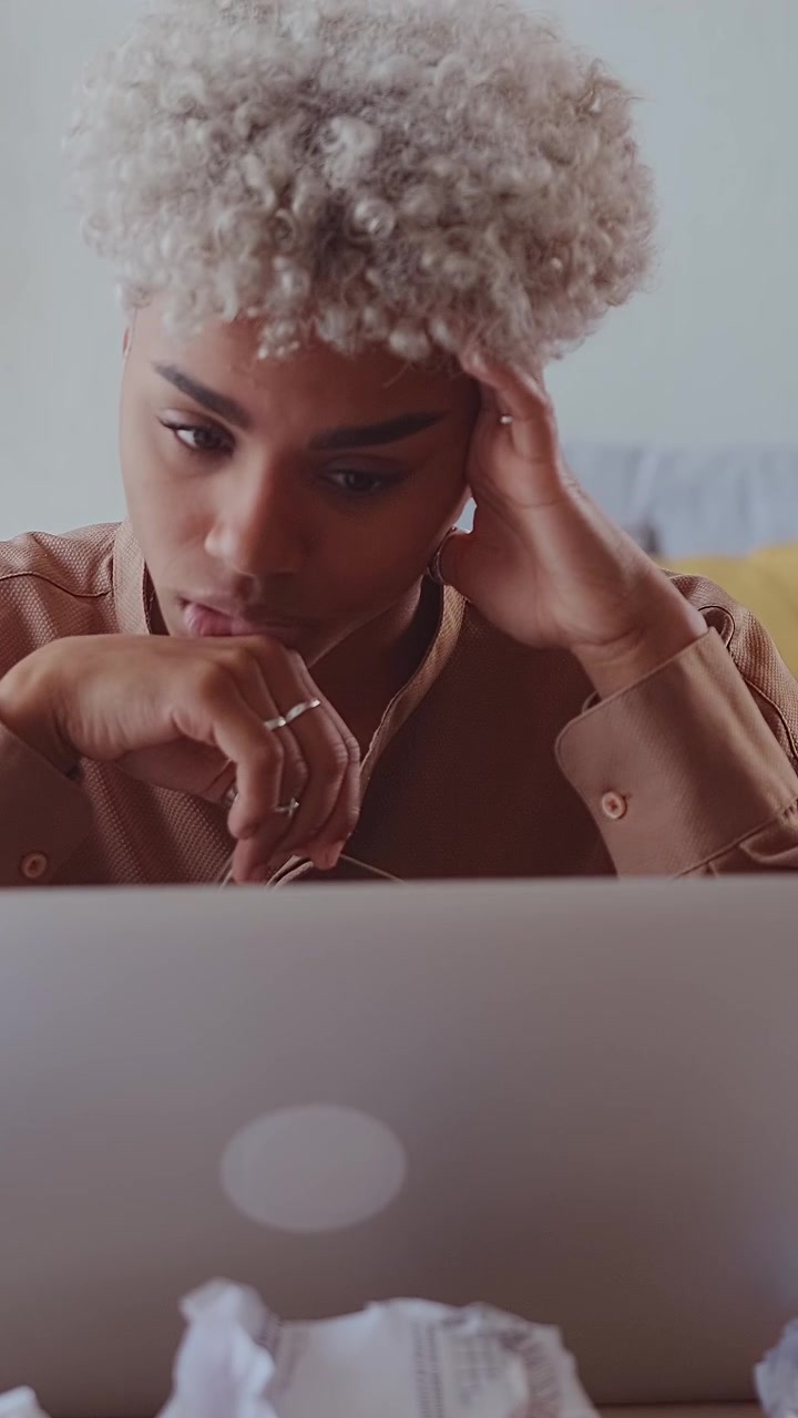 Tired african american freelancer taking off glasses and sighing in front of
