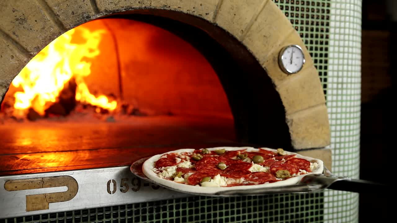 나무 로 연소 된 오븐 에서 피자 를 는 것