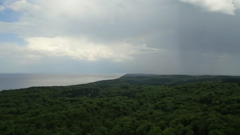 rainbow fading through storm clouds over baltic sea in coastline in swinoujscie, poland