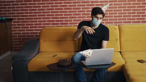 man in mask, lonely guy closing laptop after distant birthday celebration