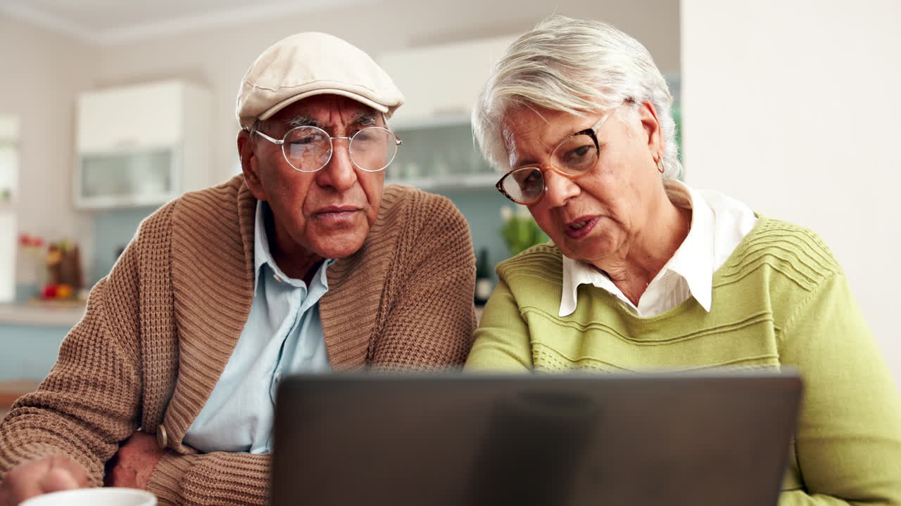 Elderly couple using a laptop at home