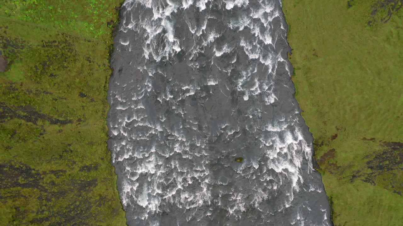 Aerial: Top down reveal shot of the famous Skogafoss waterfall in Iceland
