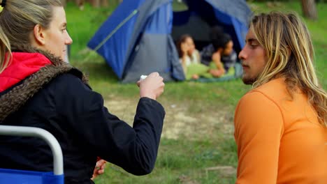 woman feeding man with marshmallow near campfire 4k