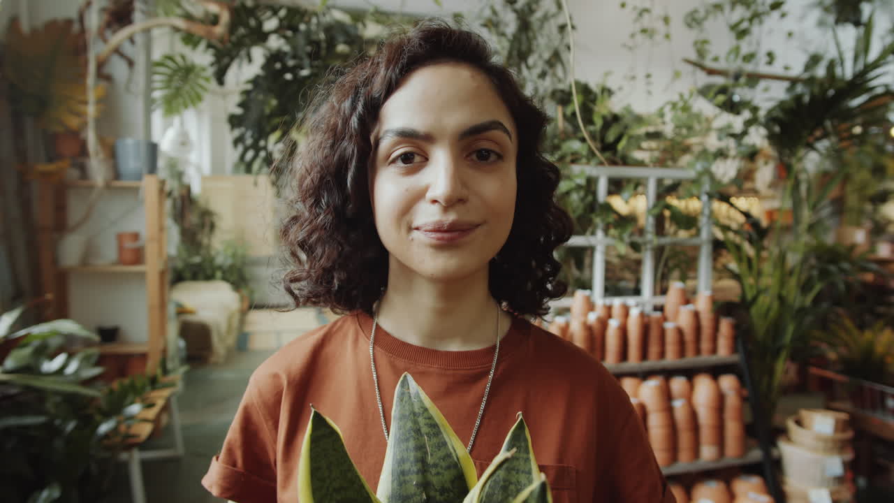 retrato de una niña joven con una planta en una tienda de flores