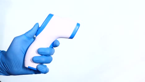 persona con un termómetro sin contacto con guantes azules