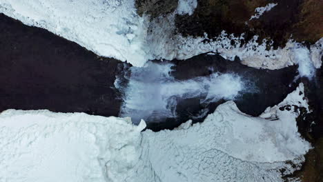 vista aérea de la cascada svodufoss con nieve y hielo en el río holmkelsa en islandia
