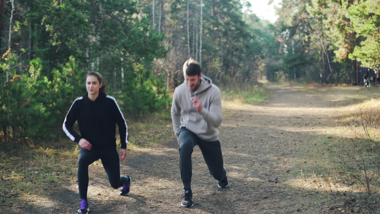 Couple exercising outdoors in autumn forest