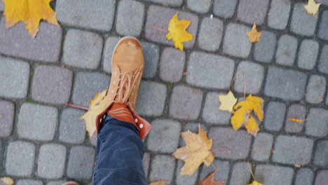 Weibliche-Beine-In-Stiefeln-Gehen-Den-Bürgersteig-Entlang,-Wo-Die-Gefallenen-Herbstblätter-Liegen-Pov-Video