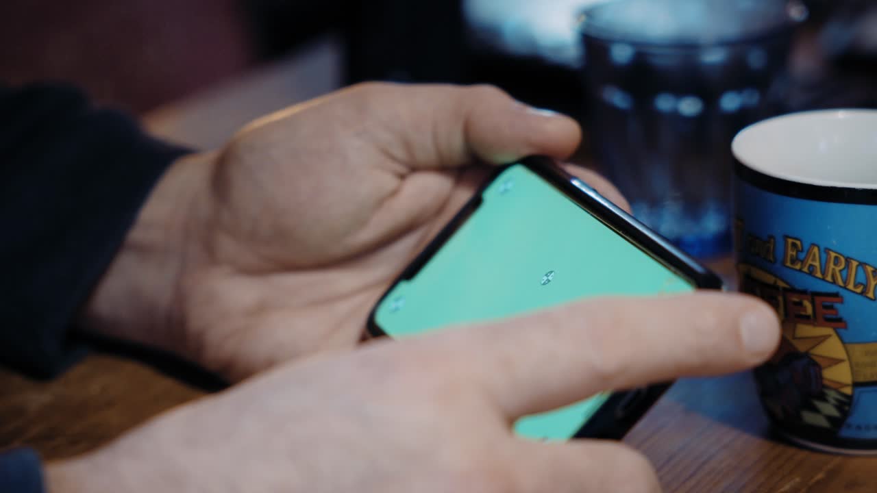 Hands holding smartphone, green screen, digital interaction symbol, modern tech