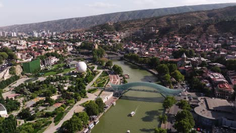 aerial pullback reveals rike park, bridge of peace. downtown tbilisi, georgia