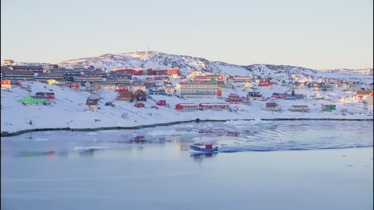 눈으로 인 해안선과 바다에 배가 있는 도시