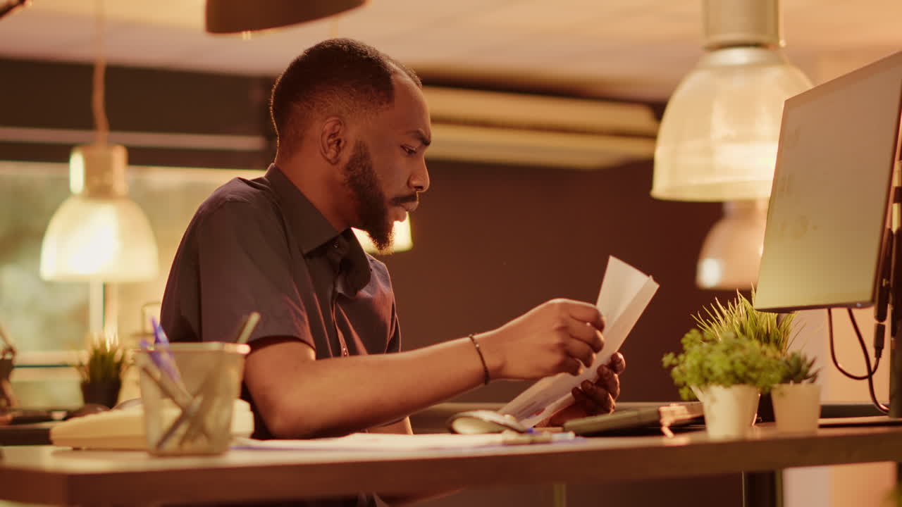 Man working in office with documents and computer