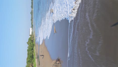 Vuelo-Bajo-Sobre-La-Playa-De-Arena-De-Playa-Dorada-En-Verano---República-Dominicana---Tiro-Vertical