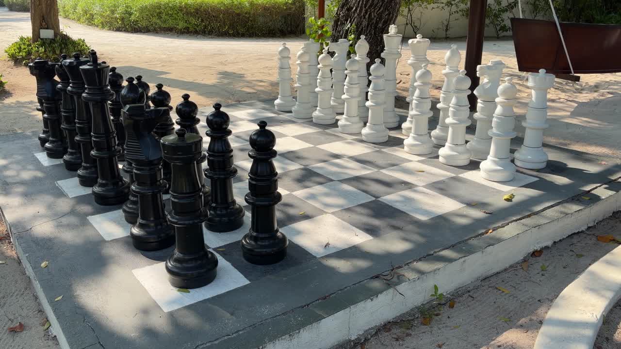 Bahçe çiminde büyük taşlarla açık hava dev satranç takımı.