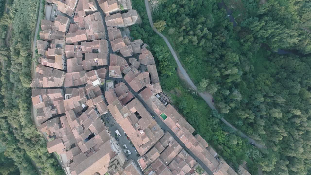 Top Down Aerial Drone view of the hilltop Medieval town of Pitigliano, Tuscany in morning light, with red tile roofs and old buildings, in 4K