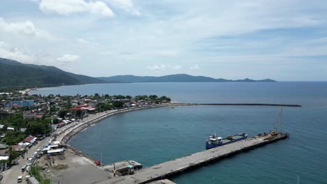 Alta-Vista-Aérea-De-Drones-Del-Idílico-Frente-Al-Mar-Barangay-Y-El-Muelle-En-Virac,-Catanduanes,-Filipinas