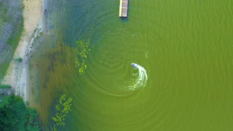 luxury boat in dark color, fast movement on blue water, aerial view