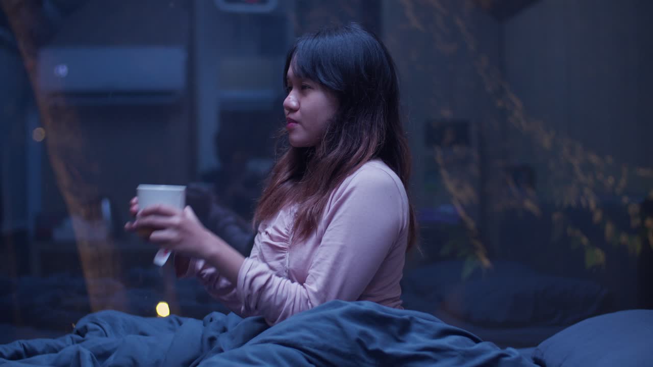 Indonesian girl enjoying a warm cup of tea under night sky