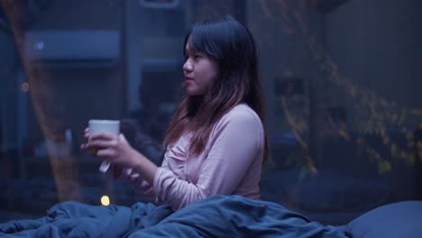 indonesian girl enjoying a warm cup of tea under night sky