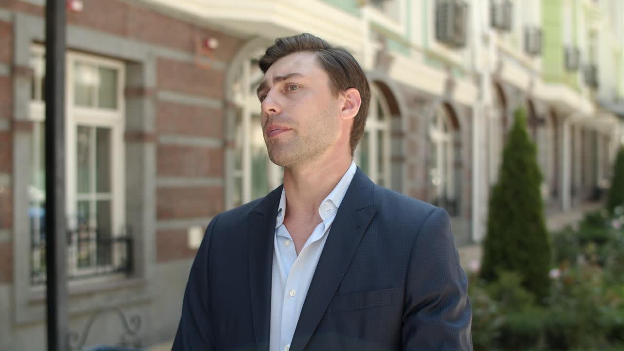 가까운 남자가 거리에서 파트너를 기다리고 있다. 남자가 스마트 워치에서 시간을 확인하고 있다.