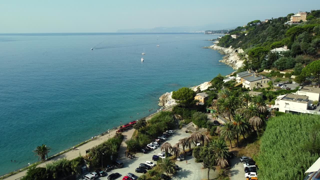 Aerial view of coastline with houses, trees, beach and parking lot