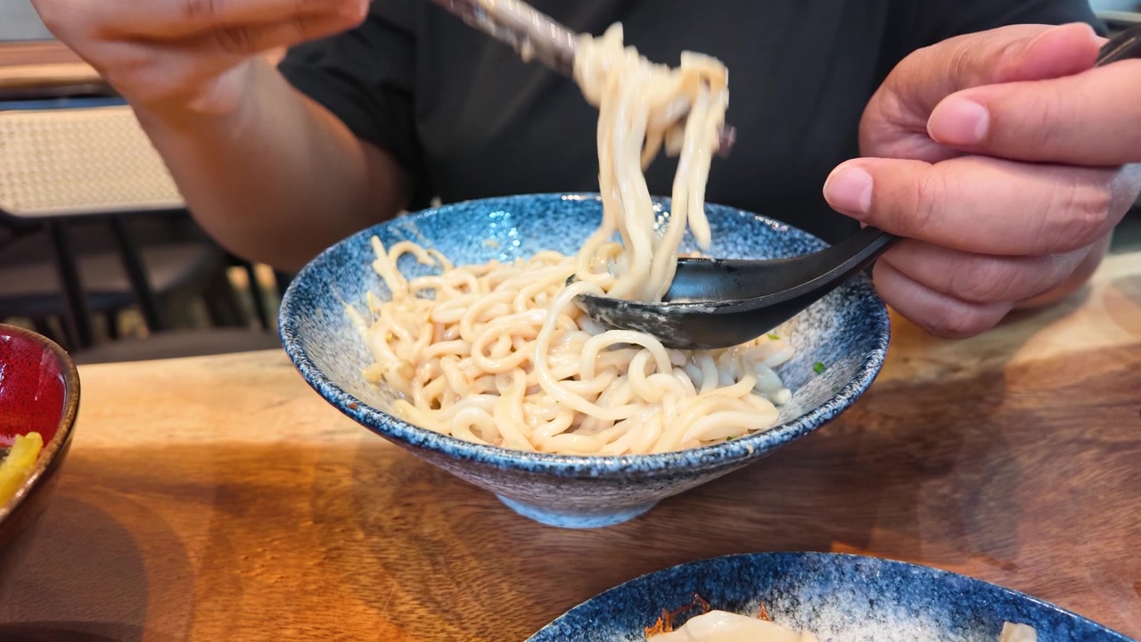 Orang Makan Mi dengan Sumpit dan Sendok di Restoran