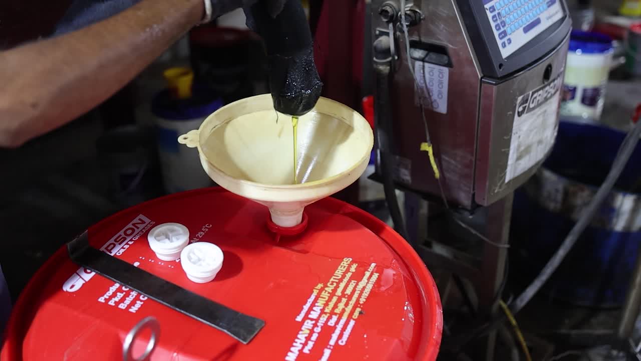 man open the valve and lubricant oil is spill to barrel, industry 5.0