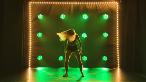 mujer bailando en el escenario con luces verdes