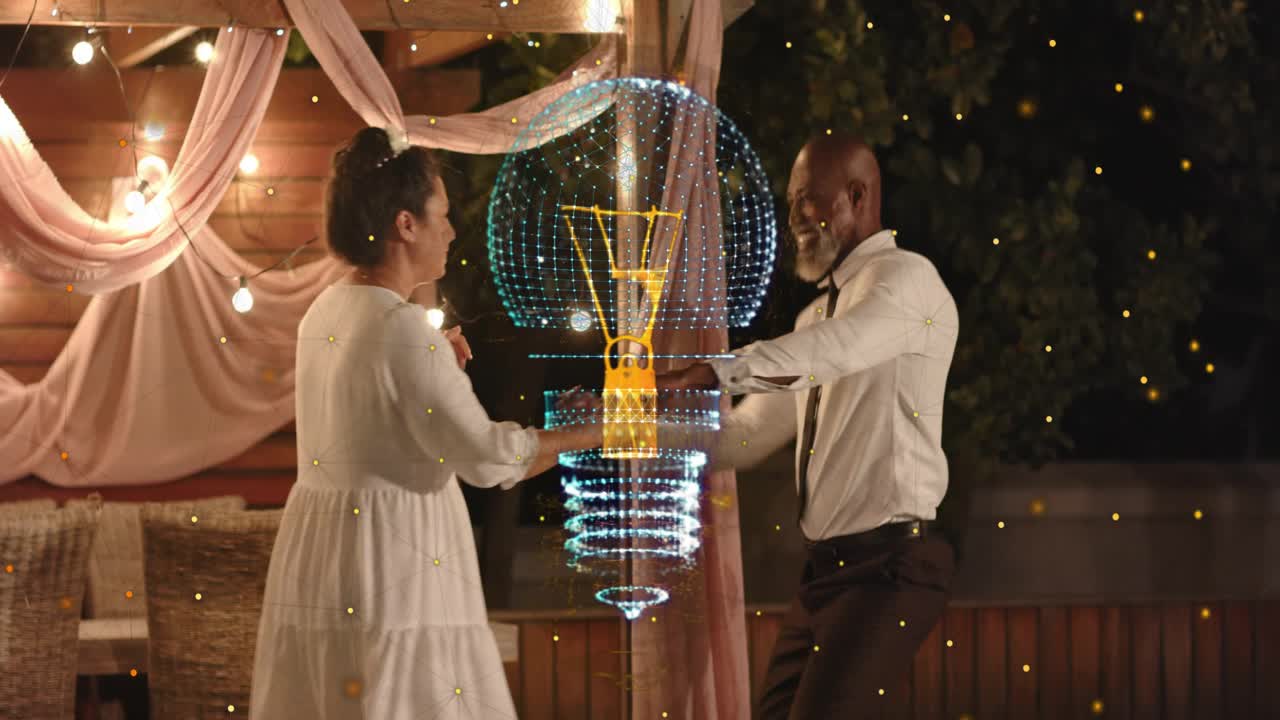 Mature couple celebrating under drape and lights, event tech bulb appearing and guiding slow turn