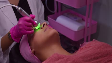una chica de piel clara en un spa recibe un tratamiento de belleza en su cara