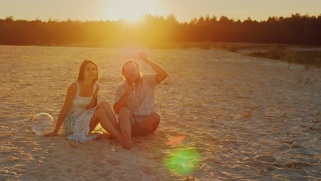 Young-Family-Having-Fun-With-Kids---Blow-Bubbles-At-Sunset