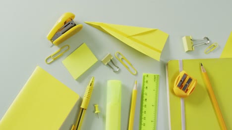 Video-of-composition-of-yellow-school-equipment-on-beige-surface