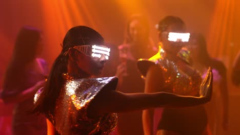 grupo de personas bailando en un club nocturno de discoteca al ritmo de la música de dj en el escenario