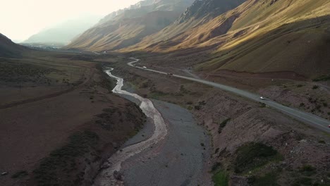 Aerial-view-of-a-truck-traveling-the-route-between-the-mountains-in-Los-Andes,-Argentina