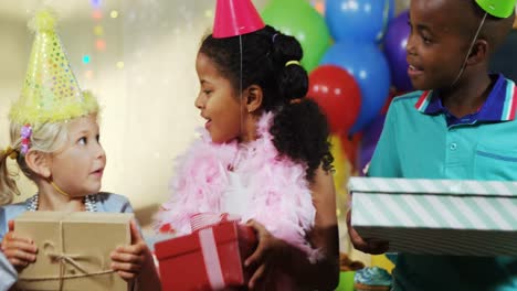 niños sosteniendo cajas de regalos durante la fiesta de cumpleaños 4k