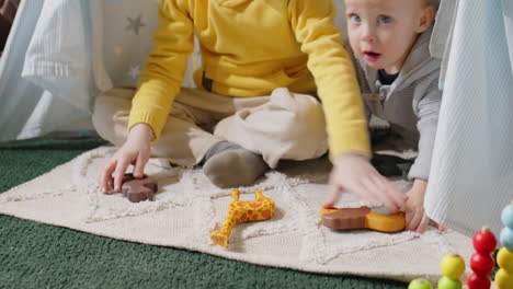 kids playing with toys in teepee at home