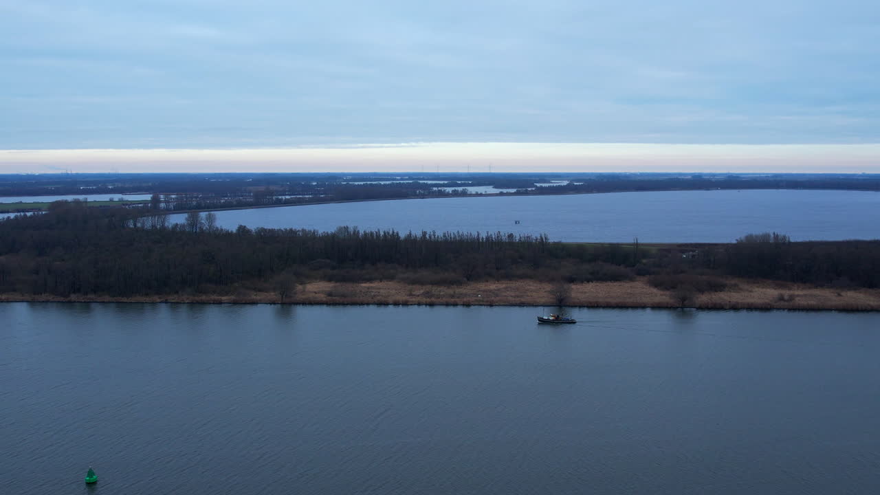 네덜란드 남부 강 하류를 여행하는 소형 선박의 중간 드론 샷