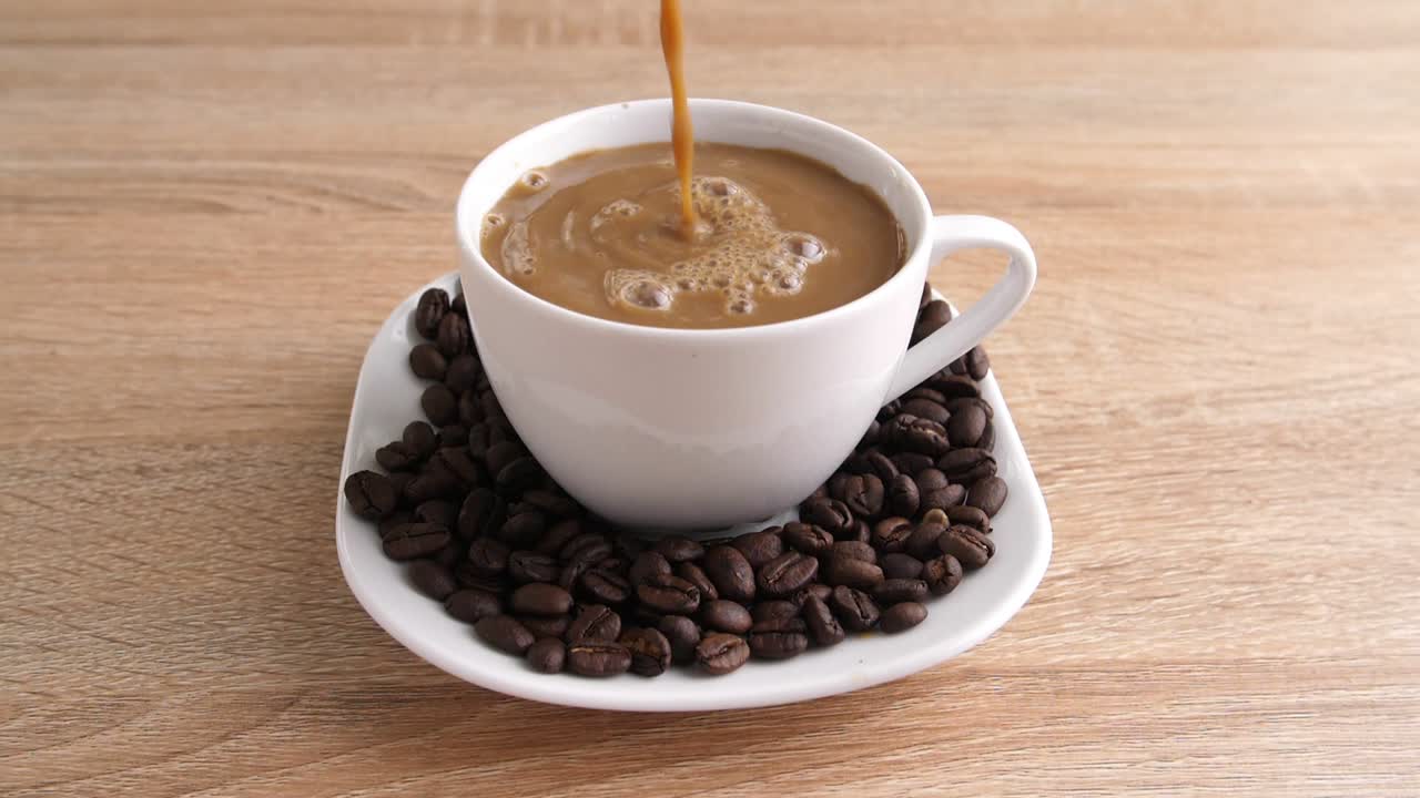Coffee Pouring into Cup with Coffee Beans