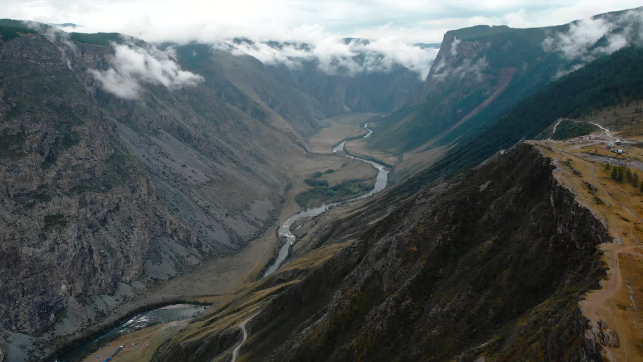 Scenic Aerial View of a Mountain Valley with River and Clouds